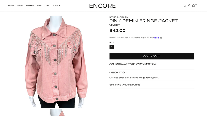 A pink denim fringe jacket displayed on a mannequin against a white ecommerce background, with product details and an 'Add to Cart' button on the right. The jacket has silver rhinestone fringe across the chest and shoulders.