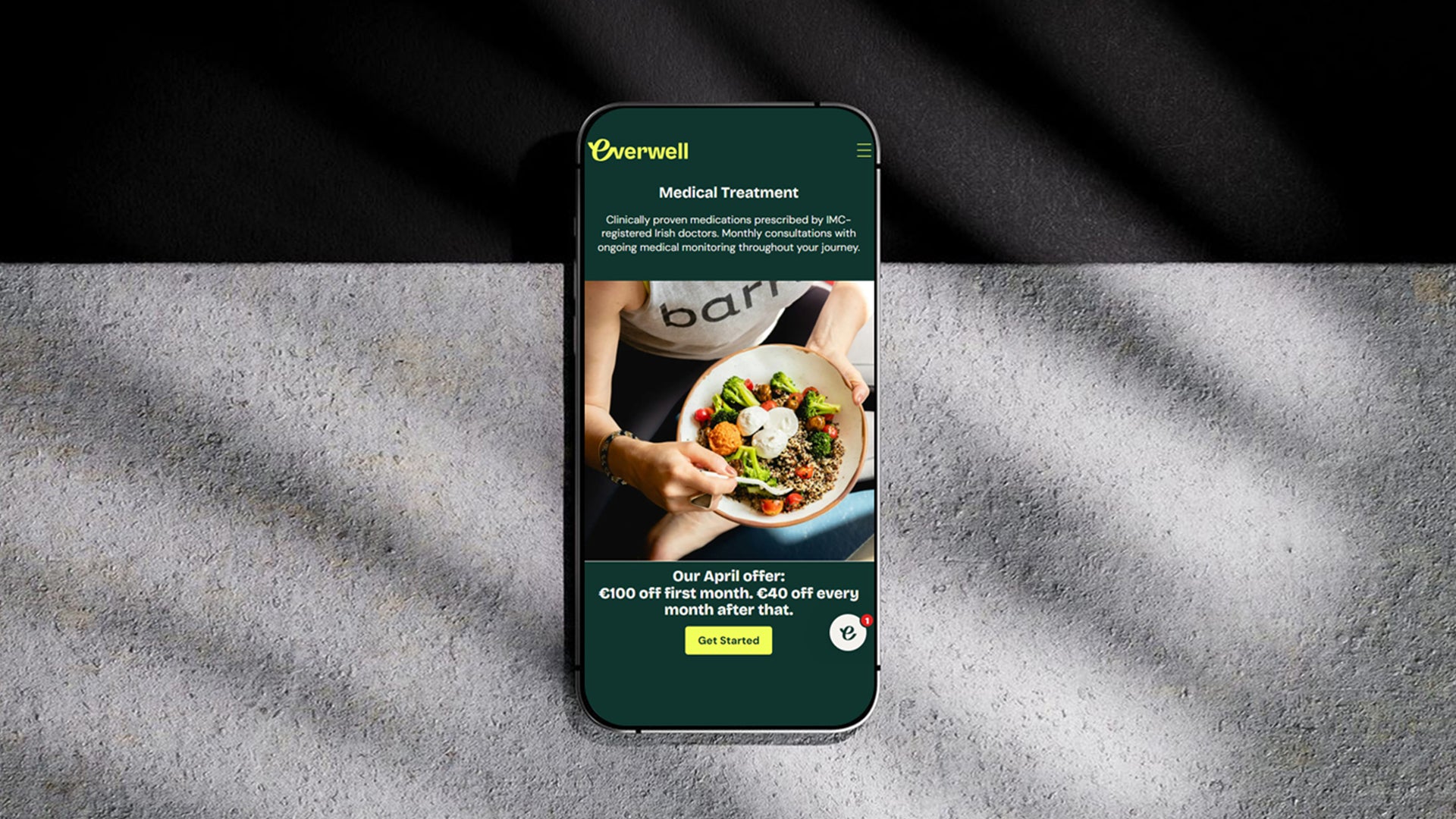 Phone displaying an everwell Shopify Website interface developed by TRMC on a textured surface with a black background